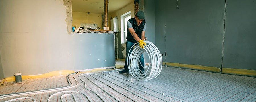 Technician installing radiant floor heating tubing