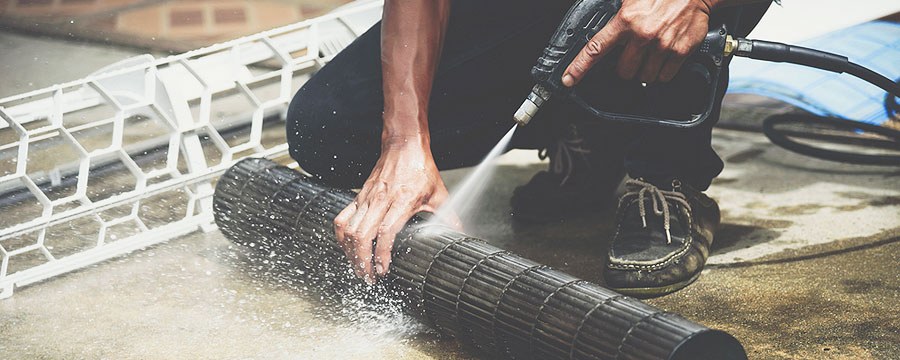 Technician cleaning an air conditioning component
