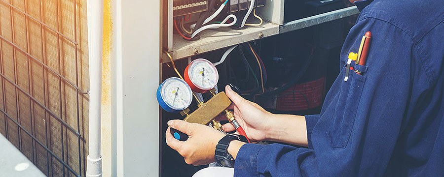 Technician checking an HVAC system with manifold gauges