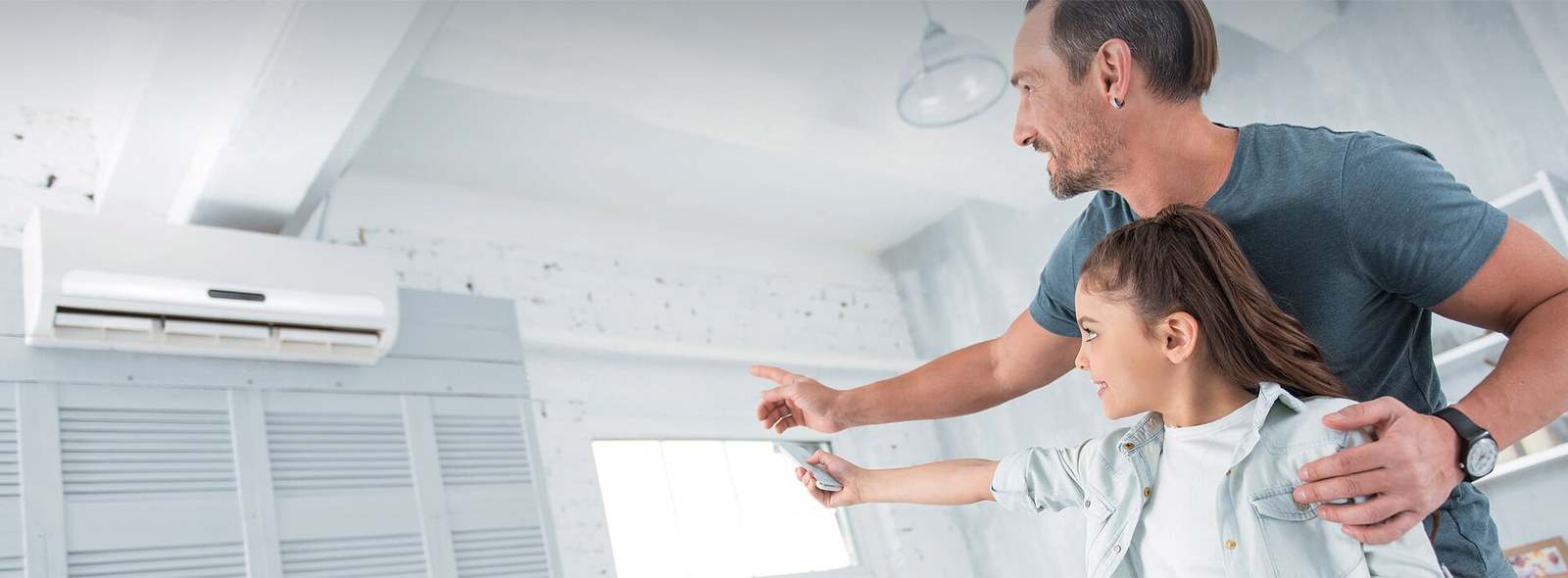 Father and daughter using a ductless air conditioner at home